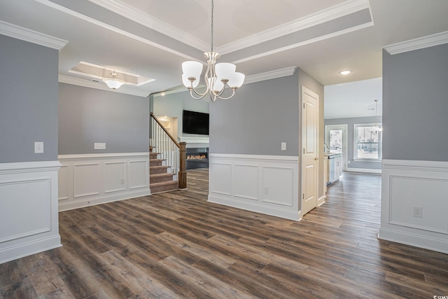 2004 Potomac Ct, Myrtle Beach, SC 29579 - spare room with crown molding, dark wood-style floors, a chandelier, a lit fireplace, and a raised ceiling