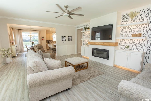 5059 Sundrop Ln, Little River, SC 29566 - living room featuring a chandelier, ornamental molding, light wood-style floors, a glass covered fireplace, and a ceiling fan