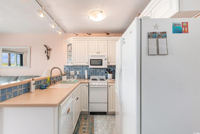 5905 S Kings Hwy Unit 605, Myrtle Beach, SC 29575 - kitchen featuring white appliances, a sink, a textured ceiling, tasteful backsplash, and a peninsula
