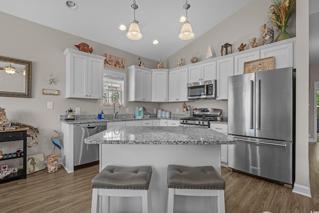 4319 Grande Harbour Blvd, Little River, SC 29566 - kitchen featuring appliances with stainless steel finishes, white cabinets, wood finished floors, lofted ceiling, and decorative light fixtures