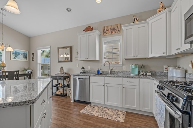 4319 Grande Harbour Blvd, Little River, SC 29566 - kitchen featuring appliances with stainless steel finishes, a sink, white cabinetry, wood finished floors, and a chandelier