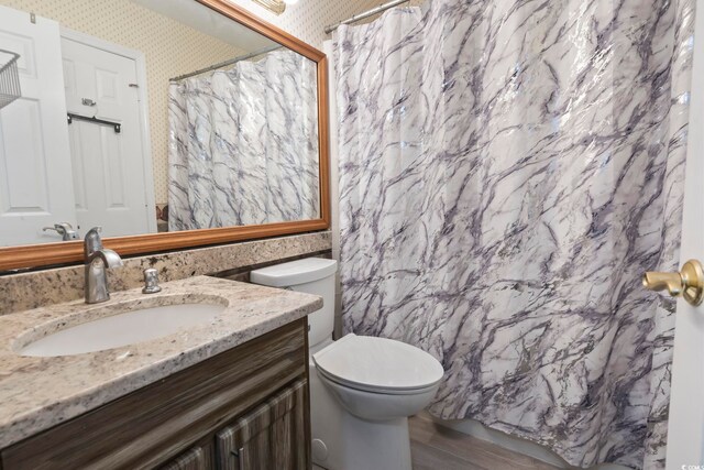 1100 Possum Trot Rd Unit C-203, North Myrtle Beach, SC 29582 - full bathroom featuring wallpapered walls, vanity, toilet, wood finished floors, and a shower with curtain