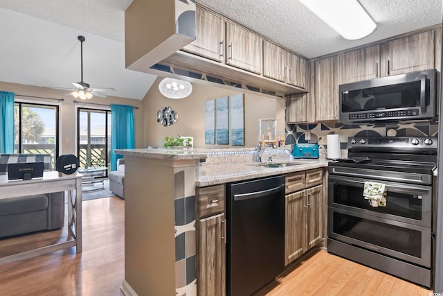 1100 Possum Trot Rd Unit C-203, North Myrtle Beach, SC 29582 - kitchen with stainless steel appliances, a sink, a peninsula, open floor plan, and a textured ceiling