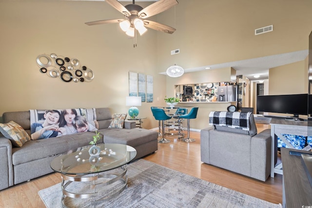 1100 Possum Trot Rd Unit C-203, North Myrtle Beach, SC 29582 - living room featuring wood finished floors, a towering ceiling, a ceiling fan, and baseboards