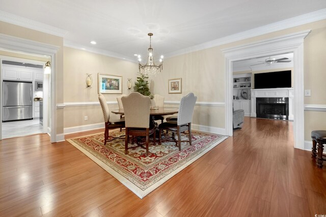 113 Trotter Trl, Georgetown, SC 29440 - dining area featuring a chandelier, wood finished floors, a fireplace, baseboards, and ornamental molding
