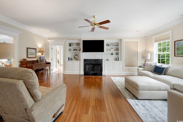 113 Trotter Trl, Georgetown, SC 29440 - living room featuring ceiling fan, light wood-style floors, a fireplace with flush hearth, ornamental molding, and built in shelves