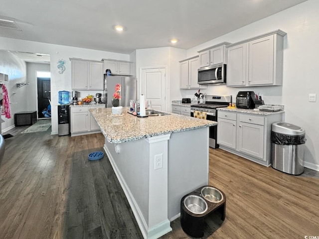 2230 Ainsley Dr, Little River, SC 29566 - kitchen featuring stainless steel appliances, dark wood finished floors, a center island with sink, light stone countertops, and recessed lighting