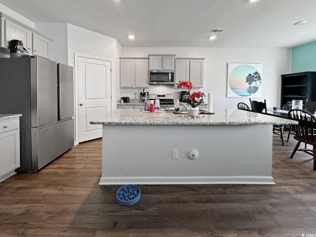 2230 Ainsley Dr, Little River, SC 29566 - kitchen featuring stainless steel appliances, light stone countertops, a kitchen island with sink, dark wood-style flooring, and recessed lighting