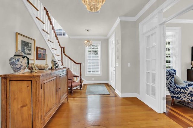 92 High Hammock Way, Pawleys Island, SC 29585 - foyer entrance featuring a chandelier, light wood-type flooring, stairs, plenty of natural light, and crown molding