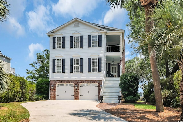 92 High Hammock Way, Pawleys Island, SC 29585 - view of front of property featuring concrete driveway, brick siding, stairs, an attached garage, and a balcony
