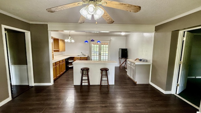 6805 Mclaurin Rd, Mullins, SC 29574 - kitchen featuring a kitchen bar, light countertops, a ceiling fan, dark wood-type flooring, and crown molding