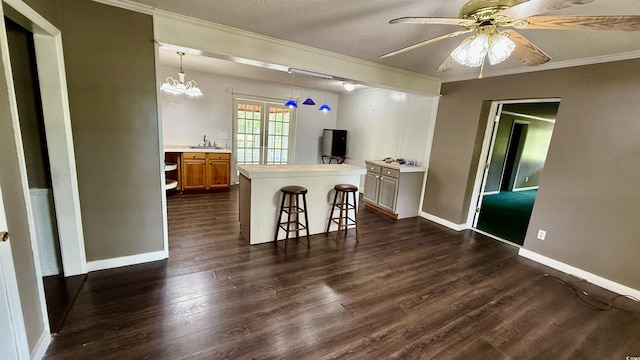 6805 Mclaurin Rd, Mullins, SC 29574 - kitchen with light countertops, crown molding, dark wood-style floors, a breakfast bar area, and a kitchen island