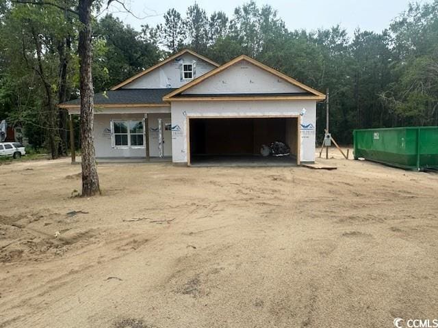 146 Temple Dr, Aynor, SC 29511 - property in mid-construction with an attached garage, dirt driveway, and stucco siding