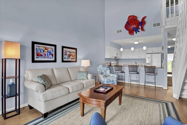 1912 Goose Creek Rd SW Unit 4302, Ocean Isle Beach, NC 28469 - living room featuring light wood finished floors, a high ceiling, and baseboards