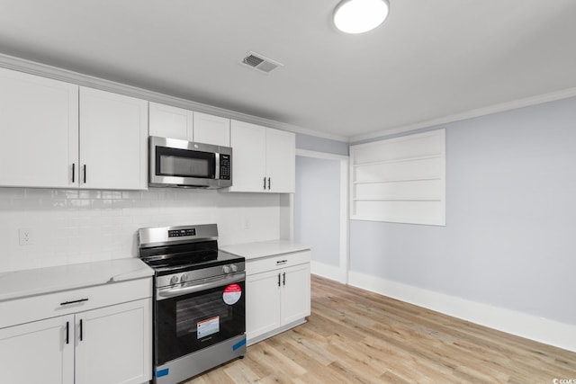 401 S Nichols St, Nichols, SC 29581 - kitchen with stainless steel appliances, crown molding, light countertops, white cabinetry, and tasteful backsplash
