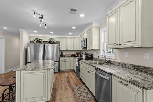 1616 S Ocean Blvd, North Myrtle Beach, SC 29582 - kitchen with stainless steel appliances, a sink, a kitchen island, ornamental molding, and a kitchen bar