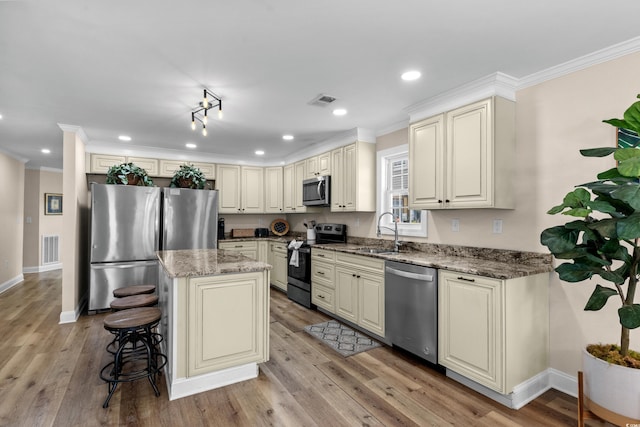 1616 S Ocean Blvd, North Myrtle Beach, SC 29582 - kitchen with stainless steel appliances, a sink, cream cabinets, crown molding, and recessed lighting