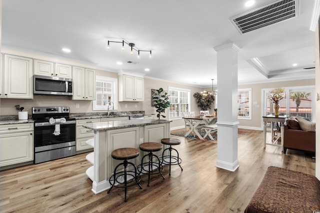 1616 S Ocean Blvd, North Myrtle Beach, SC 29582 - kitchen featuring stainless steel appliances, ornate columns, crown molding, a sink, and plenty of natural light