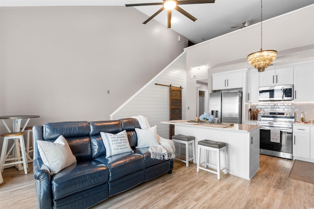 210 Double Eagle Dr Unit B-2, Surfside Beach, SC 29575 - living area with high vaulted ceiling, ceiling fan, a barn door, light wood-style flooring, and a chandelier