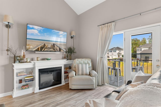 210 Double Eagle Dr Unit B-2, Surfside Beach, SC 29575 - living room with wood finished floors, vaulted ceiling, a glass covered fireplace, and baseboards