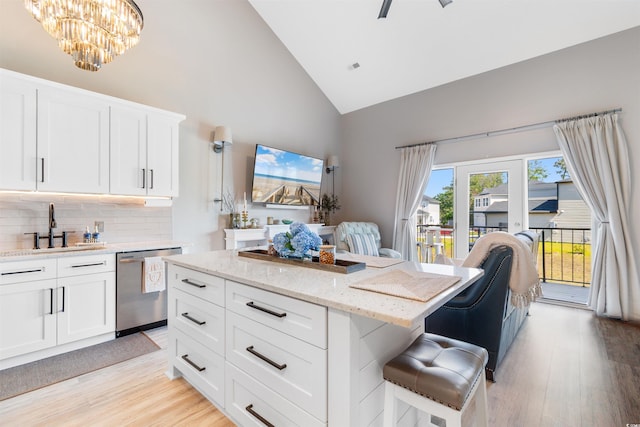 210 Double Eagle Dr Unit B-2, Surfside Beach, SC 29575 - kitchen with stainless steel dishwasher, a sink, high vaulted ceiling, a breakfast bar, and light wood-style flooring