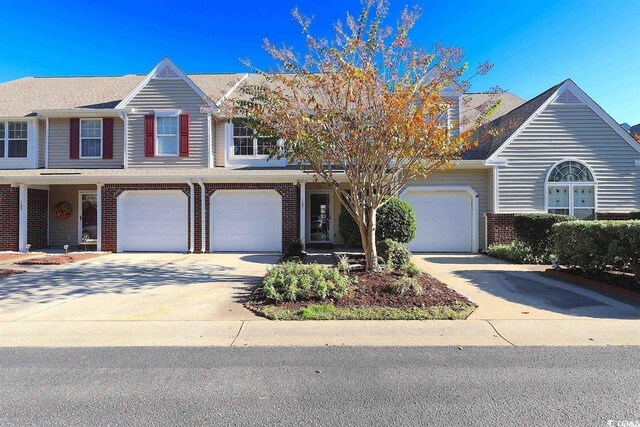 107 Pawleys Place Dr Unit 107, Pawleys Island, SC 29585 - view of property with brick siding, concrete driveway, and an attached garage