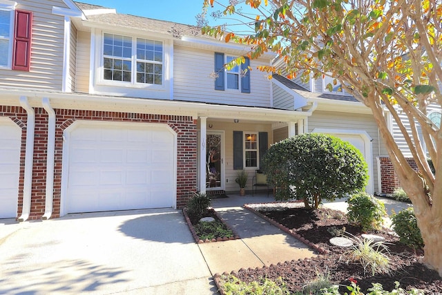 107 Pawleys Place Dr Unit 107, Pawleys Island, SC 29585 - view of front of property with brick siding, an attached garage, driveway, and a porch