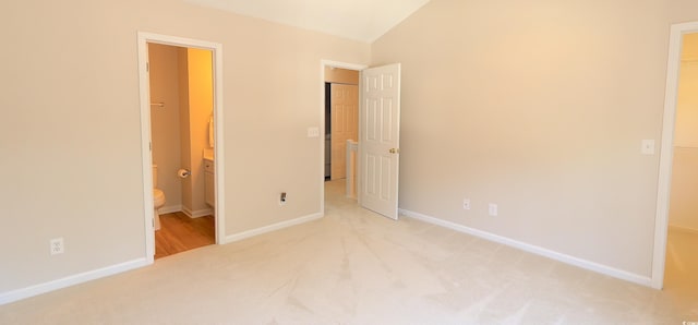 107 Pawleys Place Dr Unit 107, Pawleys Island, SC 29585 - unfurnished bedroom with carpet, baseboards, vaulted ceiling, ensuite bath, and a spacious closet
