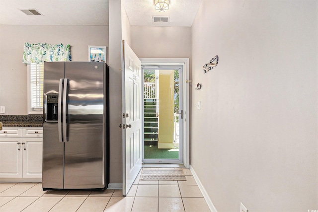 601 Hillside Dr N Unit 2135, North Myrtle Beach, SC 29582 - kitchen with stainless steel fridge, light tile patterned floors, baseboards, and white cabinets