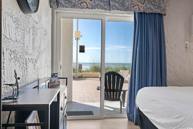 1207 S Ocean Blvd Unit 20109, Myrtle Beach, SC 29577 - bedroom featuring light wood finished floors, a textured wall, a water view, and access to outside