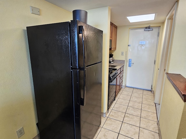 5300 N Ocean Blvd Unit 306, Myrtle Beach, SC 29577 - kitchen featuring black appliances, brown cabinets, and light tile patterned flooring