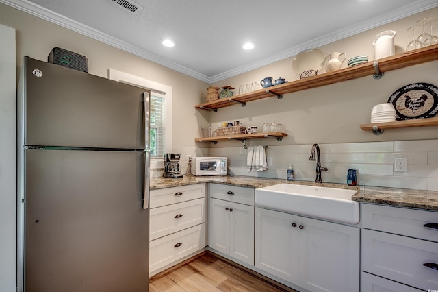 112 Blue Gull Dr, Conway, SC 29526 - kitchen with freestanding refrigerator, open shelves, a sink, ornamental molding, and white microwave