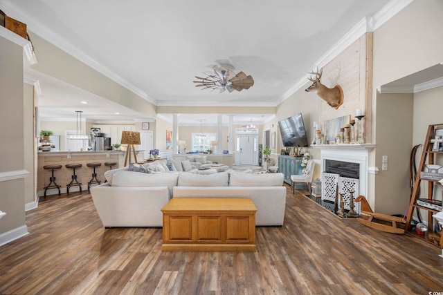7005 Wellesley Ct, Murrells Inlet, SC 29576 - living area with wood finished floors, crown molding, ceiling fan, a fireplace, and a chandelier