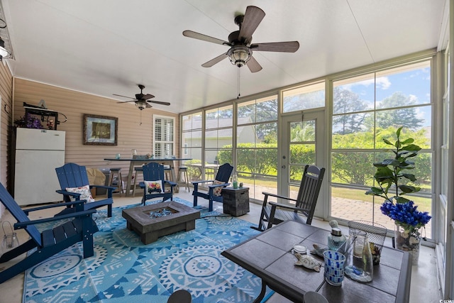 7005 Wellesley Ct, Murrells Inlet, SC 29576 - sunroom featuring an outdoor fire pit, ceiling fan, healthy amount of natural light, expansive windows, and wood walls