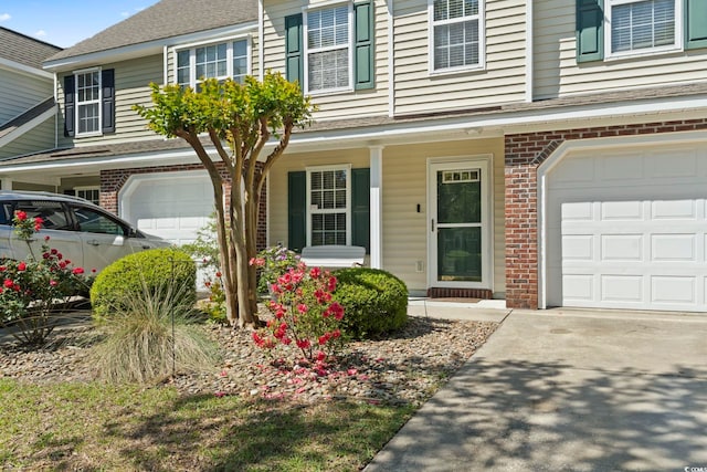 1102 Stanton Pl Unit 1102, Myrtle Beach, SC 29579 - view of front facade with an attached garage, brick siding, a porch, and concrete driveway