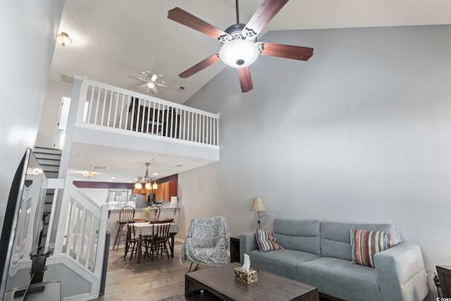 1102 Stanton Pl Unit 1102, Myrtle Beach, SC 29579 - living area featuring light wood-style floors, ceiling fan, stairway, high vaulted ceiling, and a chandelier