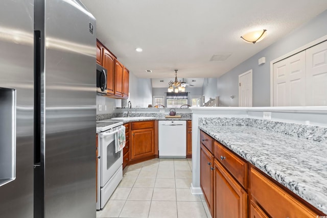 1102 Stanton Pl Unit 1102, Myrtle Beach, SC 29579 - kitchen featuring white appliances, a sink, a chandelier, light tile patterned flooring, and light stone countertops
