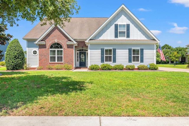 1025 Limpkin Dr, Conway, SC 29526 - traditional-style home featuring board and batten siding, a front lawn, brick siding, and roof with shingles