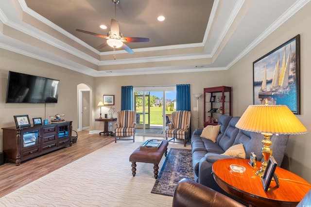 1025 Limpkin Dr, Conway, SC 29526 - living area featuring a raised ceiling, arched walkways, wood finished floors, ceiling fan, and ornamental molding