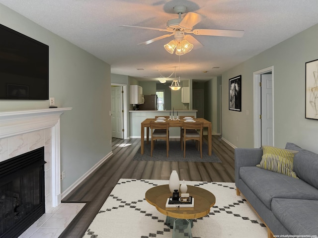 251 Egret Run Ln Unit 1122, Pawleys Island, SC 29585 - living area with ceiling fan, wood finished floors, baseboards, a tiled fireplace, and a textured ceiling