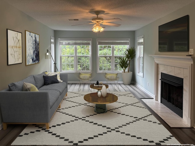 251 Egret Run Ln Unit 1122, Pawleys Island, SC 29585 - living area featuring a ceiling fan, a tile fireplace, wood finished floors, baseboards, and a textured ceiling