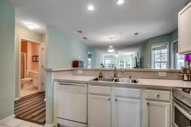 251 Egret Run Ln Unit 1122, Pawleys Island, SC 29585 - kitchen with white dishwasher, a sink, a textured ceiling, light countertops, and a ceiling fan