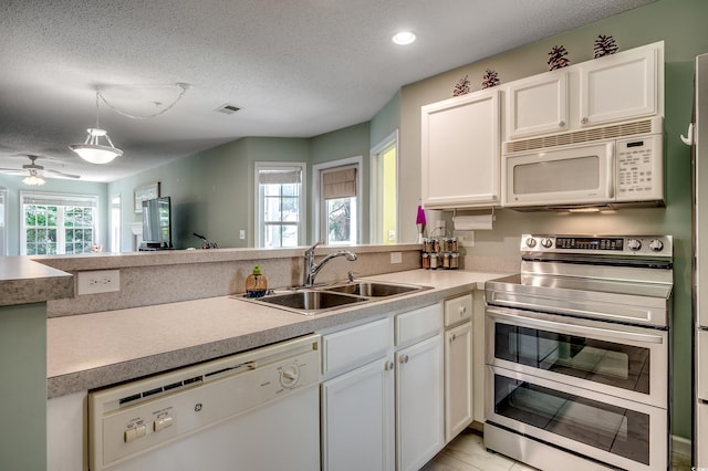 251 Egret Run Ln Unit 1122, Pawleys Island, SC 29585 - kitchen featuring white appliances, a sink, a peninsula, a textured ceiling, and light countertops