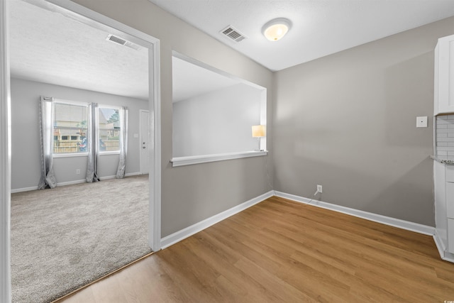 755 Burcale Rd Unit E-3, Myrtle Beach, SC 29579 - spare room featuring baseboards, light wood-style flooring, a textured ceiling, and light carpet