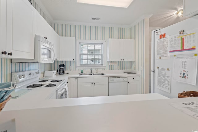 5750 Oyster Catcher Dr Unit 822, North Myrtle Beach, SC 29582 - kitchen with white appliances, wallpapered walls, light countertops, white cabinetry, and crown molding