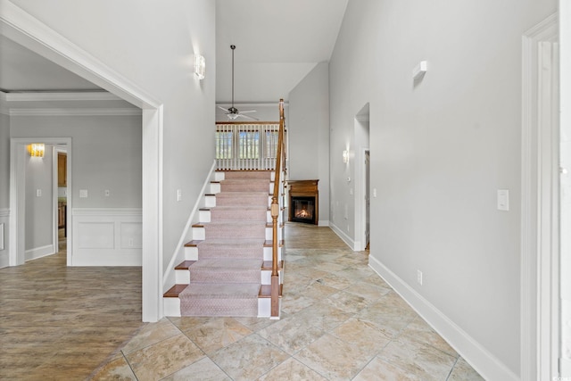 528 Chamberlin Rd, Myrtle Beach, SC 29588 - staircase featuring ceiling fan, a lit fireplace, and a towering ceiling