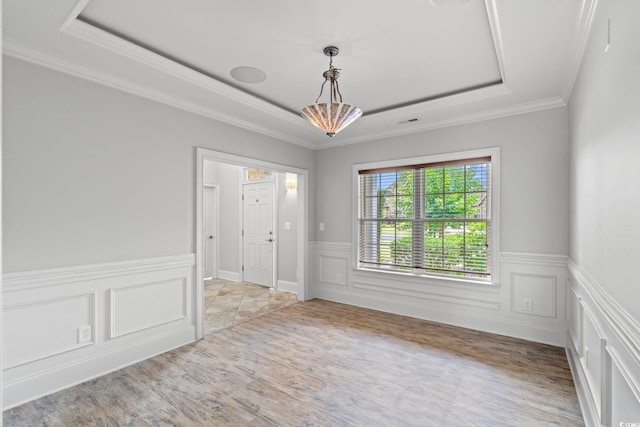 528 Chamberlin Rd, Myrtle Beach, SC 29588 - empty room with a tray ceiling, wainscoting, wood finished floors, crown molding, and a decorative wall
