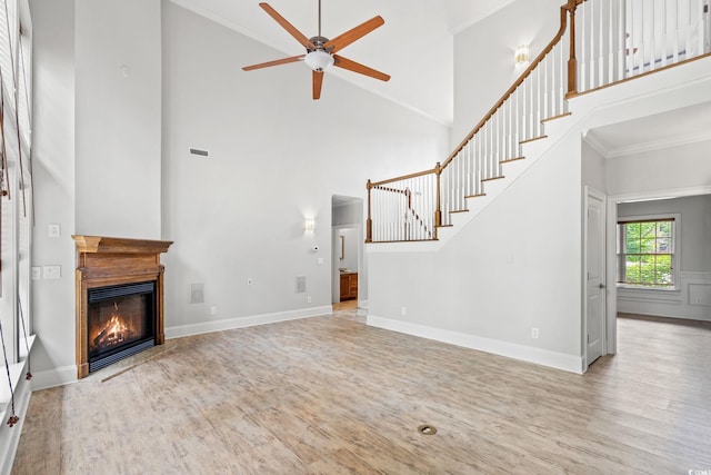 528 Chamberlin Rd, Myrtle Beach, SC 29588 - unfurnished living room with ornamental molding, wood finished floors, high vaulted ceiling, a ceiling fan, and a glass covered fireplace