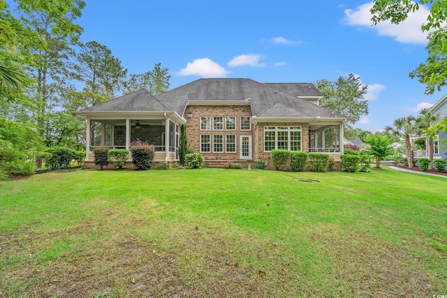 528 Chamberlin Rd, Myrtle Beach, SC 29588 - rear view of property featuring a sunroom, ceiling fan, a lawn, brick siding, and roof with shingles