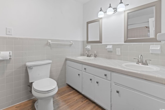 1043 S Main St, Aynor, SC 29511 - bathroom with double vanity, wood finished floors, toilet, wainscoting, and tile walls
